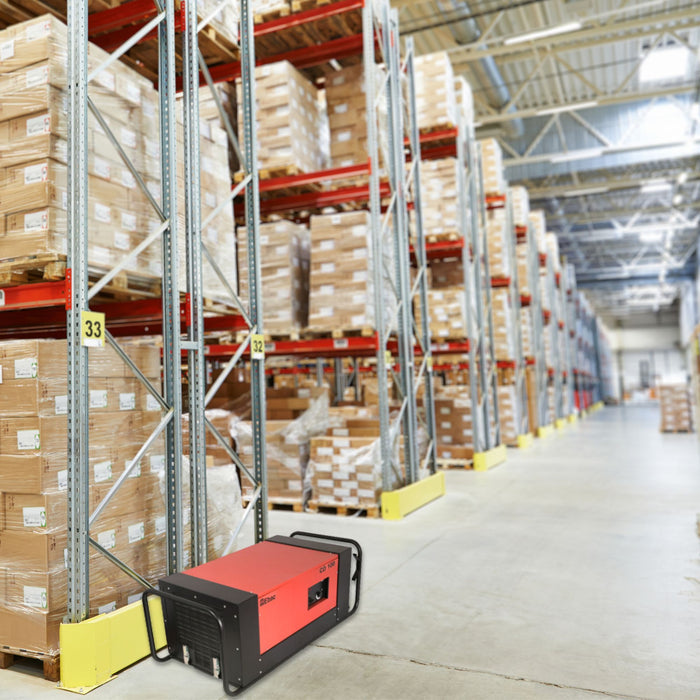 EBac CD100 heavy-duty dehumidifier placed on a warehouse floor with storage racks in the background.