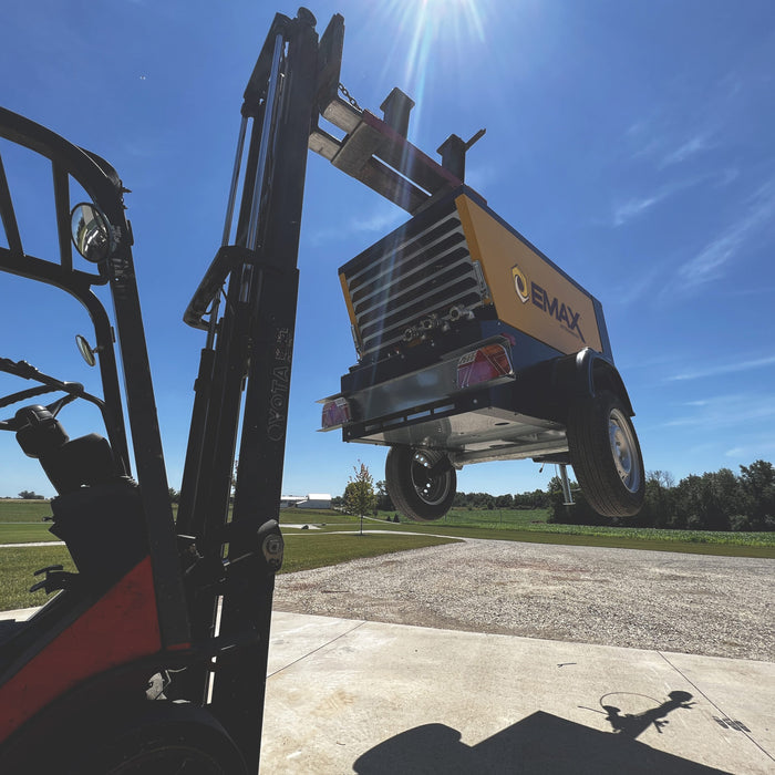 EMAX EDS090TR diesel powered air compressor being lifted by a forklift, demonstrating its portability and ease of transport.