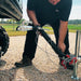 Close-up of a person connecting the hitch of the EMAX towable EDS090TR air compressor to a trailer mount.