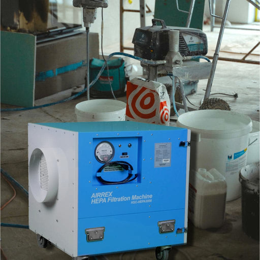 Airrex HEPA Filtration Machine (model HSC-HEPA2000) sits on a construction site floor, amidst tools and materials, improving air quality by filtering out dust and debris.